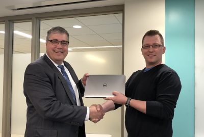 Hand shake with laptop, IT Infrastructure Manager, Jeremy Forstner, pictured right